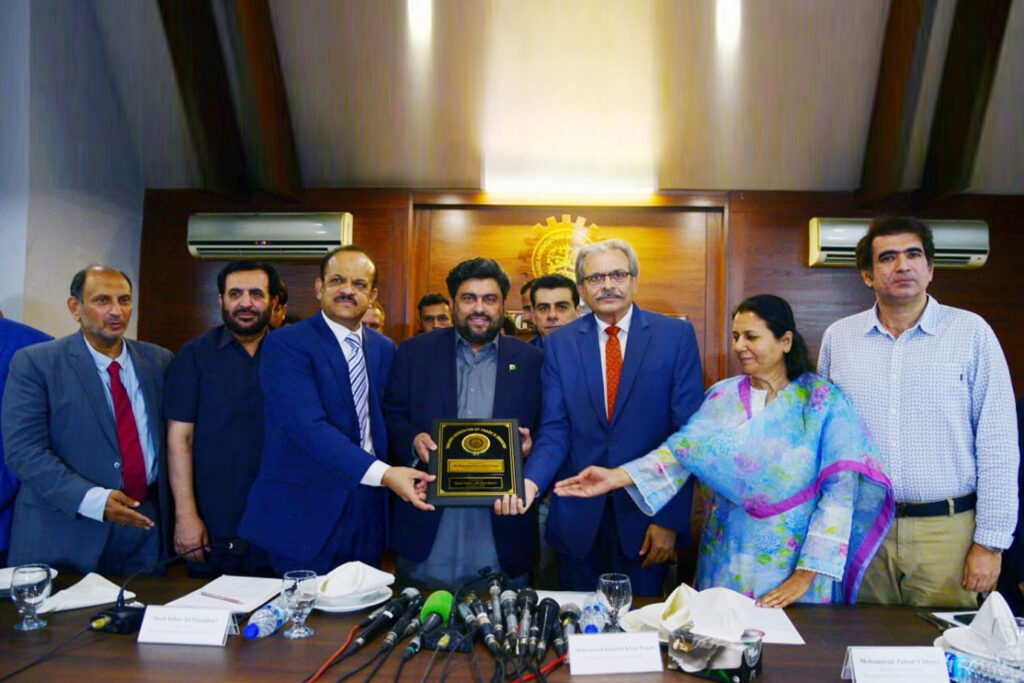 KATI President Johar Qandhari presents a shield to Sindh Governor Kamran Tessori at a ceremony. Other dignitaries present include Zubair Chhaya, Nighat Awan, Muslim Mohamedi, Zahid Saeed, and Sheikh Umer Rehan.